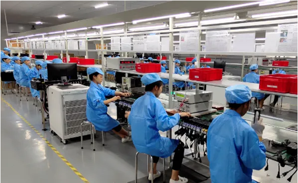 Power-adapter assembly benches with technicians and test fixtures